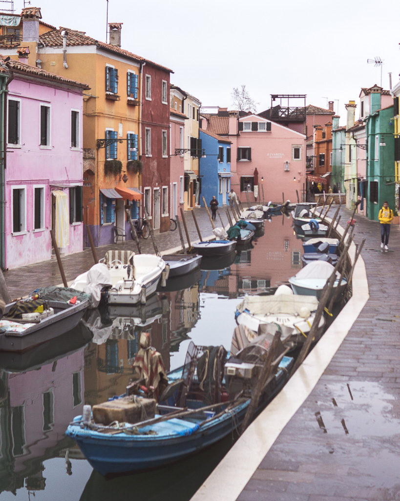 Sweeping view of main canal in Burano with multi-coloured cottages on banks near Venice