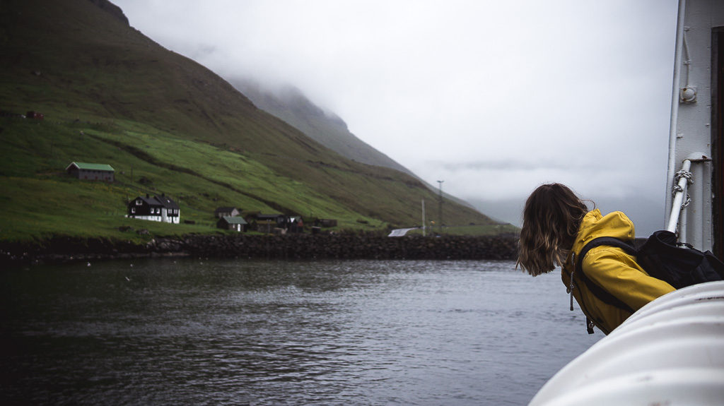 Nell leaning off the side of a boat as we pull into a harbour on the Faroe Islands.
