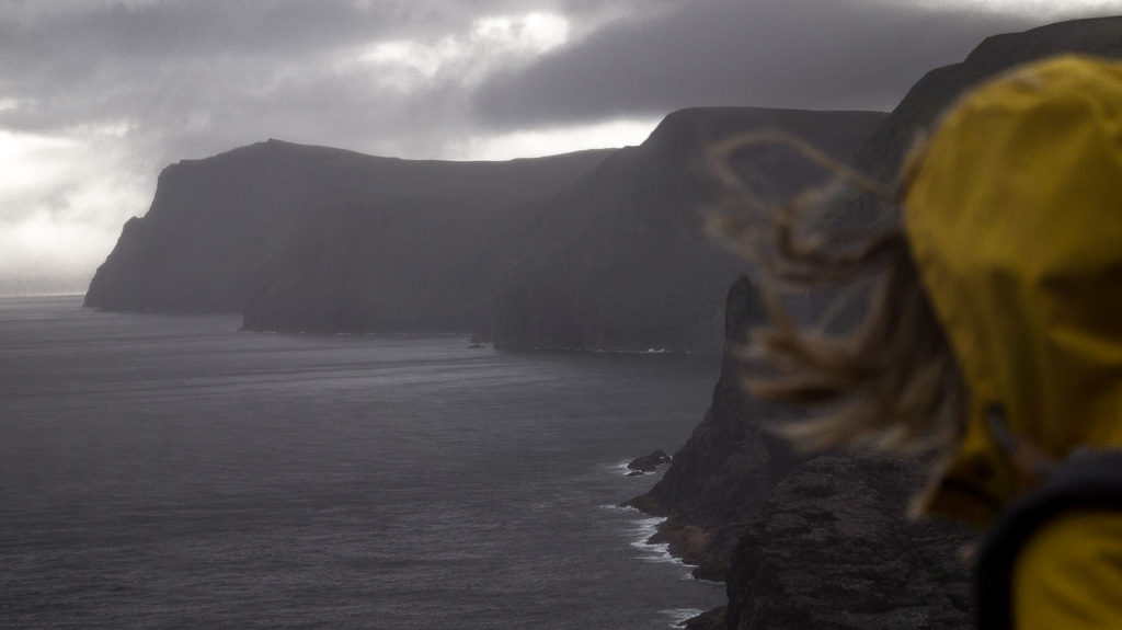 High up on a clifftop path whilst hiking on the Faroe Islands. The wind blowing Nell's hair in all directions.
