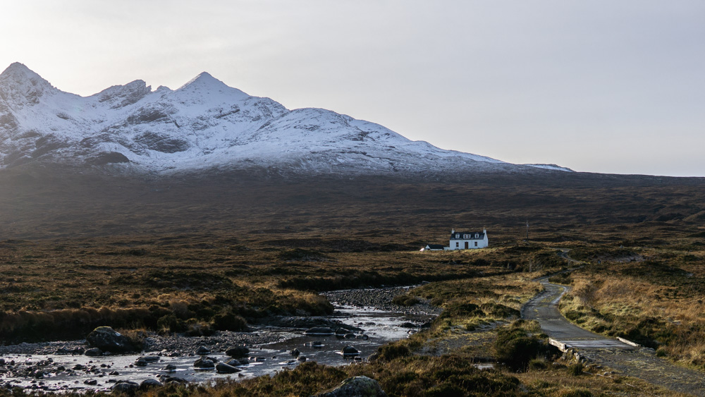 Cottage on the Isle of Skye with snow covered Cuillin mountains in background