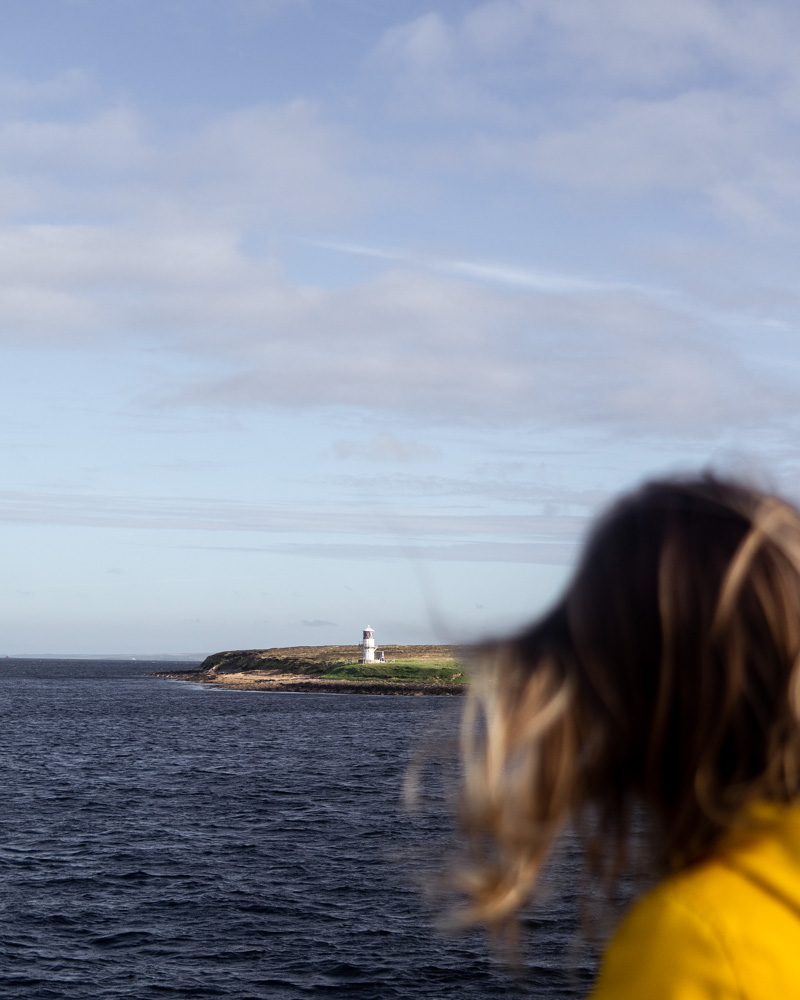 Lighthouse over Nell's shoulder on route over on ferry to Hoy